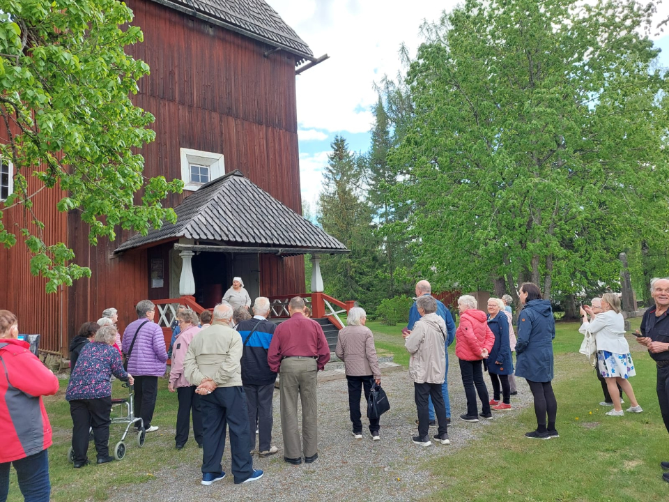 Retkeläiset menossa Keuruun vanhaan kirkkoon. Pappilan piika lakaisee portaita.