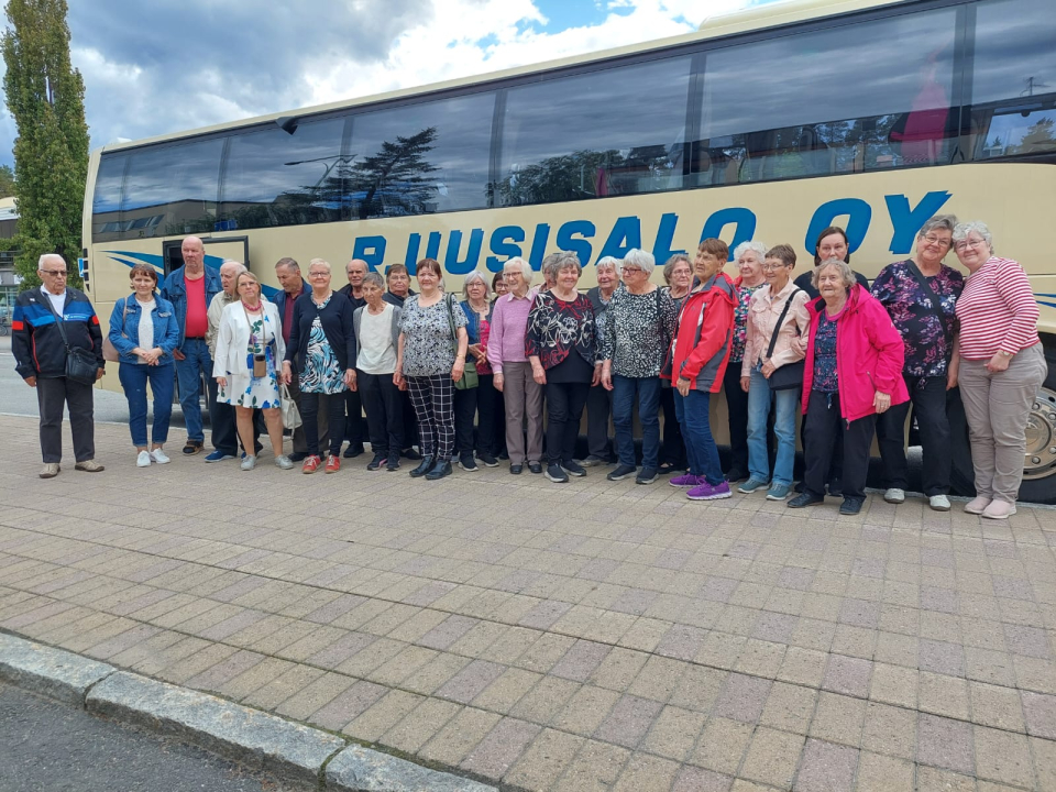 Retkiporukkaa bussin edessä