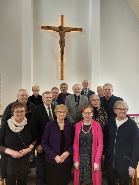 Taustalla Kyyjärven kirkon alttarin krusifiksi ja edessä syntymäpäiväsankareita.