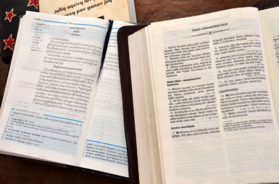 Kaksi kirjaa avoinna, joista toinen on Raamattu