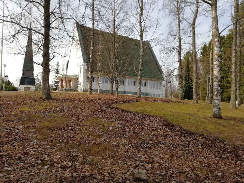 Kyyjärven kirkko syksyllä. Lehdettömät puut, syksyn lehtiä maassa.