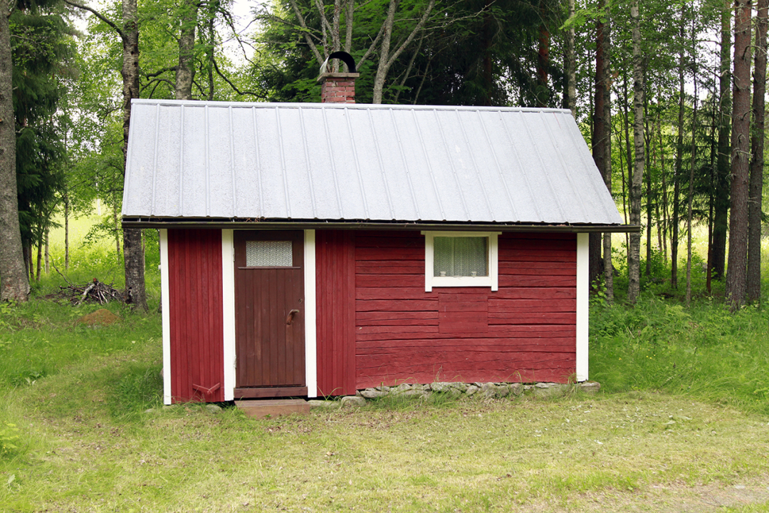 Hyvälöylyinen piha-sauna, hirsirakenteinen. Saunan takana ulko-wc ja peltoa.
